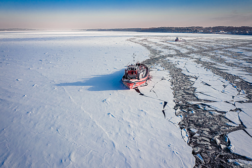 Icebreakers on river in winter. Aerial view of frozen Vistula river, Poland