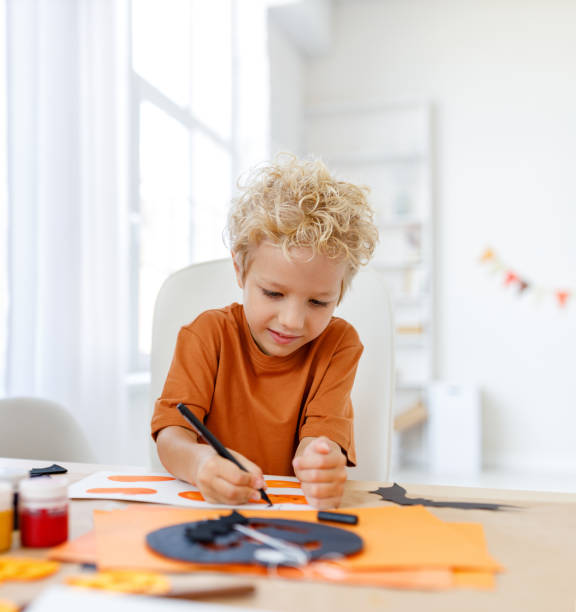 istock Cute child  boy    making Halloween home decorations 1429574799