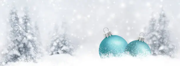 Photo of Christmas baubles in a snowy winter forest