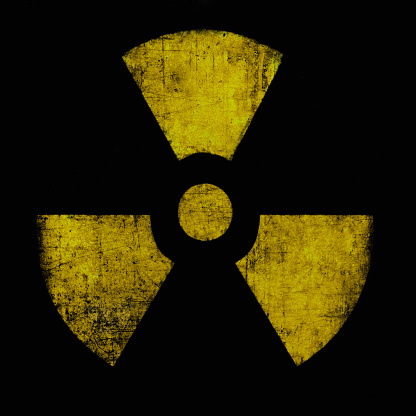 Radiation sign, yellow on black. Nuclear hazard emblem, grunge textured. Radioactive threat symbol