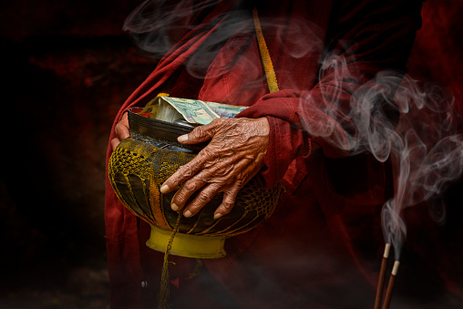 Buddhist monk hands holding alms bowl