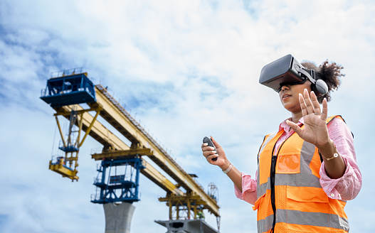 Portrait of African American Female engineer using VR gear to visualize projects on construction site.Foreman using Visual reality goggle for Blue print checking.