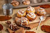 homemade pastry Cinnamon Roll Buns in rustic autumn kitchen with fresh icing sugar