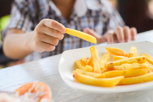 child eating french fries or potato chips.