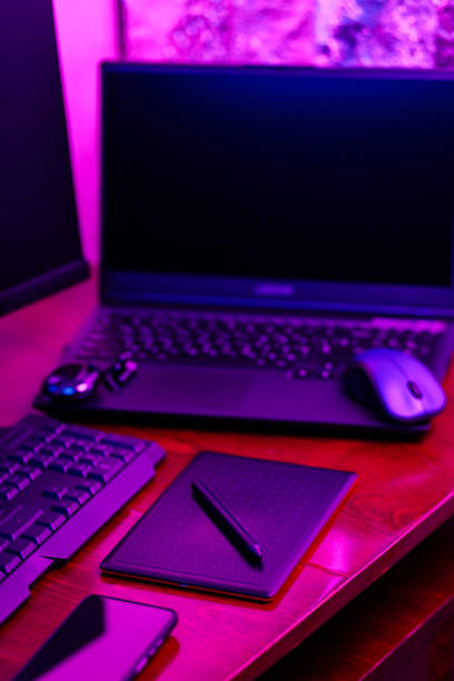 istock Workplace of a graphic designer and creative retoucher. Graphic tablet, smartphone and computer equipment in neon light. Workspace of creative designer with tablet and stylus 1429605625