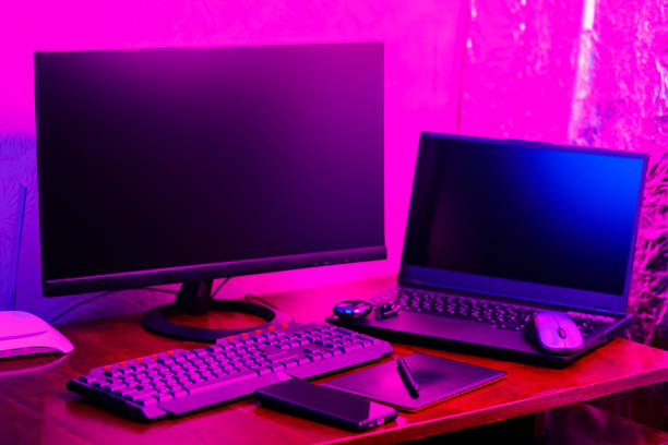 istock Workplace of a graphic designer and creative retoucher. Graphic tablet, smartphone and computer equipment in neon light. Workspace of creative designer with tablet and stylus 1429605658