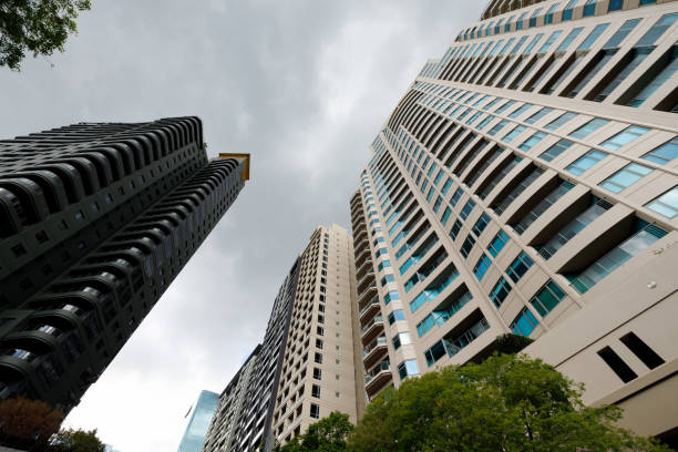 Detail of two tall tall city buildings with an overcast sky.