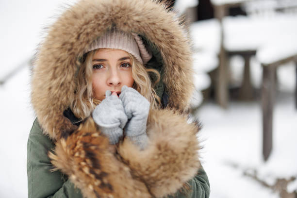 istock Young woman warming up her hands in winter forest 1429612657