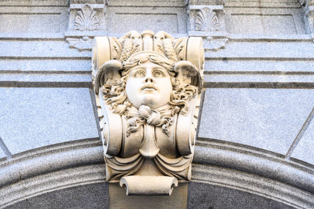Madrid, Spain - September 30, 2022: Low-angle view of a stone carving decorating the Bank of Spain building. The detail is a portrait bust of a woman.