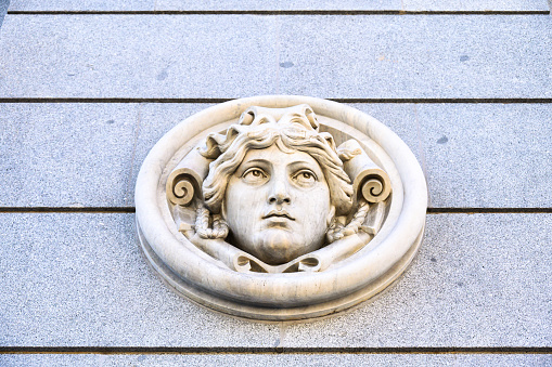 Madrid, Spain - September 30, 2022: Stone-carved decoration in the facade of the Bank of Spain building. The detail is a bust sculpture of a man.