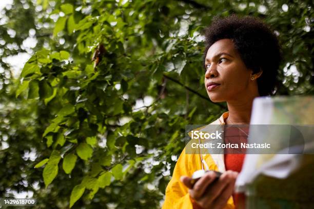 African American Woman Holding Map And Compass Stock Photo - Download Image Now - Navigational Compass, 20-29 Years, 25-29 Years