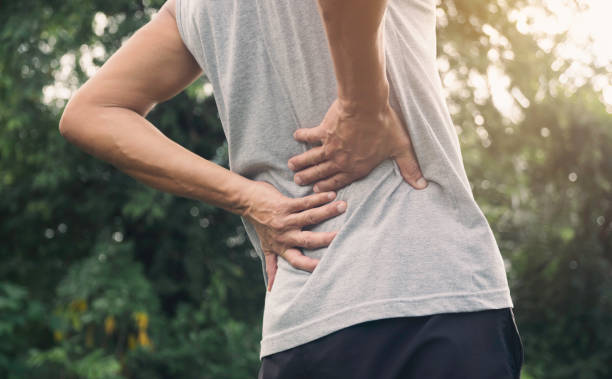 istock Man get injured for him back walking exercise outdoor accident. 1429619435