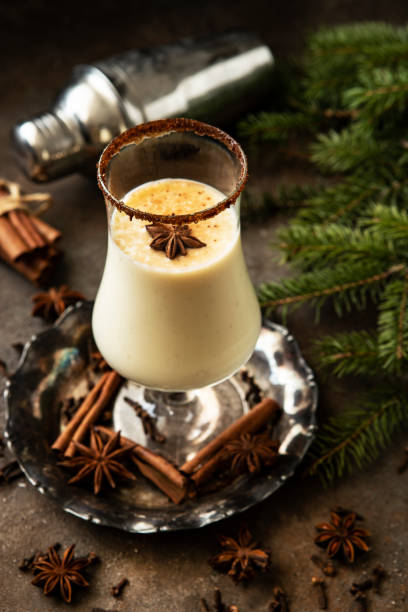 istock Glass of Christmas spiced eggnog   with tree branches on dark background 1429620815
