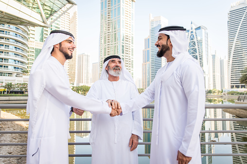 Group of arabian businessmen with kandura meeting outdoors in UAE - Middle-eastern men in Dubai