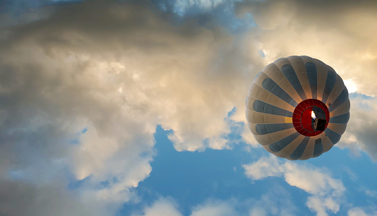 Colorful hot air balloon flying above the clouds