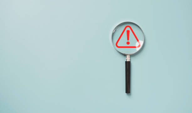 istock Magnifier glass with red triangle caution warning sign for notification error and maintenance concept. 1429631091