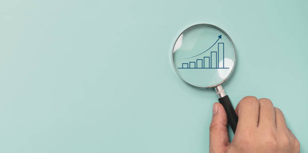 istock Trader hand holding magnifier glass with bar graph with increasing arrow for analysis technical graph of stock market chart , Business investment concept. 1429631216