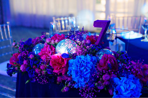 decorated in disco style table in a dark banquet hall. disco balls and flowers in the decor of the restaurant.