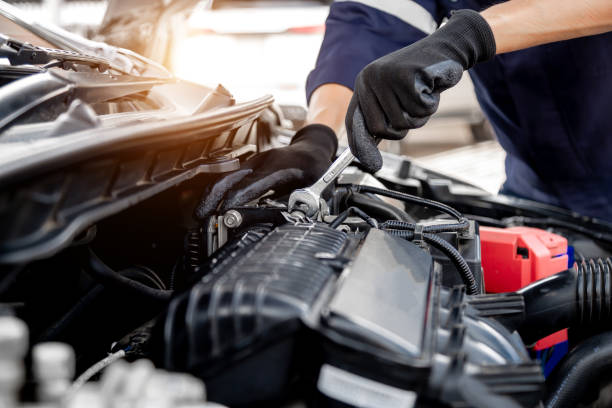 entretien et entretien de la voiture, technicien en gros plan mécanicien automobile utilisant la clé pour réparer le problème de changement de moteur de voiture de pièce de rechange et le soutien du service d’assurance. - auto repair shop photos et images de collection