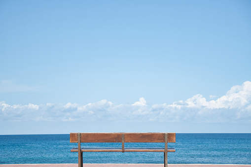 Back view of an empty bench with sea views. Concept of tranquility, freedom, peace, joy.