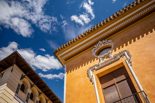 Colorful facades of the old town of Mula, in Murcia, Spain with the intense blue sky in the background