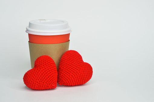 White cup with coffee beans and hearts