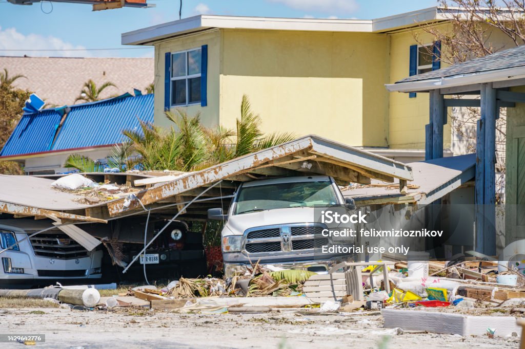 Camión inmovilizado bajo los escombros de la tormenta Huracán Ian Fort Myers FL - Foto de stock de Huracán Ian libre de derechos
