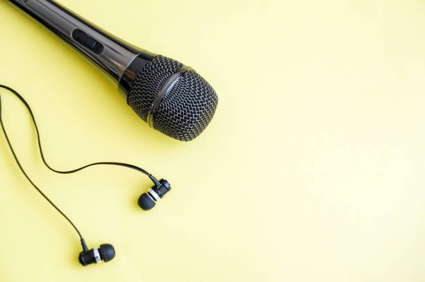 istock Grey microphone and headphones on a yellow background with space for writing 1429647901