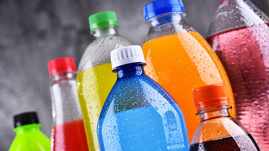 Plastic bottles of assorted carbonated soft drinks in variety of colors
