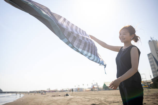 istock Happy woman dancing with scarf in beach 1429656437