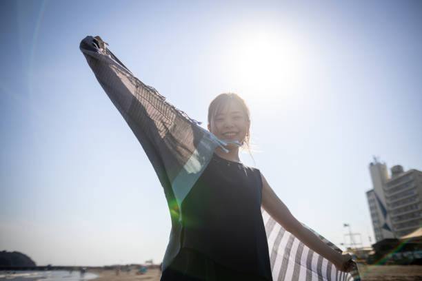 istock Happy woman dancing with scarf in beach - looking at camera 1429656541