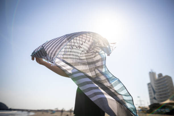 istock Happy woman dancing with scarf in beach - rear view 1429656606