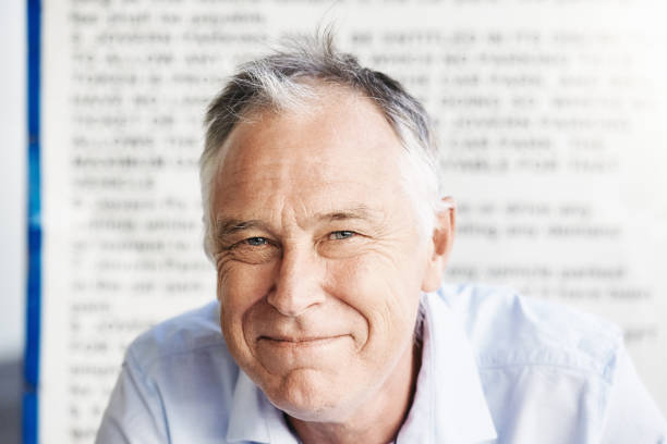 istock Handsome, happy middle-aged man against a background of blurred text 1429657048