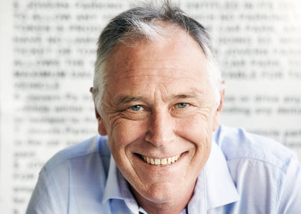 istock Handsome, happy middle-aged man against a background of blurred text 1429657123