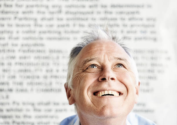 istock Handsome, happy middle-aged man against a background of blurred text 1429657189
