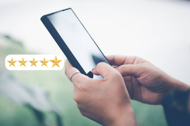 istock Customer Satisfaction Survey Concept, A man's hand using a smartphone gives a 5 star rating to show the highest level of satisfaction with excellent service.. 1429658194