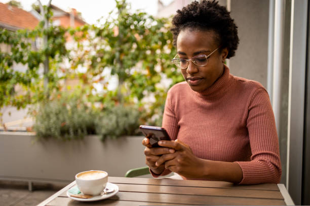 istock Smiling woman using mobile phone at the bar 1429659082