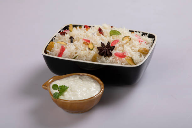 Star anise placed on cooked rice with use of selective focus on a particular part of the star anise with rest of the star anise, the cooked rice and background blurred.