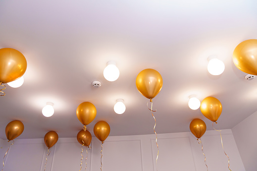 golden festive balloons on the ceiling. Simple and spectacular decoration of the house and yard for the party.