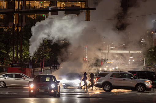 Baltimore, Maryland - October 03, 2019: Night Traffic in Baltimore, Maryland. City Street and Hot Water Steam in Background. USA