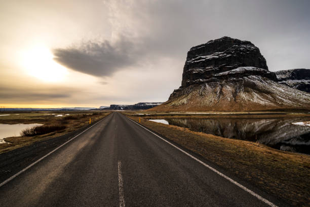 Ring Road / Route 1 leading to Lómagnúpur mountain, Iceland Wide angle shot of the Ring Road / Route 1 in southern Iceland, leading towards the mighty Lómagnúpur mountain (764 m) national road stock pictures, royalty-free photos & images