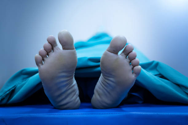 테이블에 태그가없는 시트로 덮인 시체의 발 - 죽음 물리적 묘사 뉴스 사진 이미지