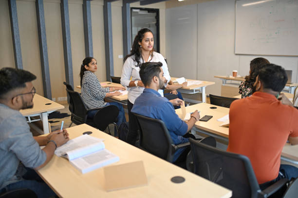 istock Teacher talking and explaining mature adult students in a classroom 1429679644