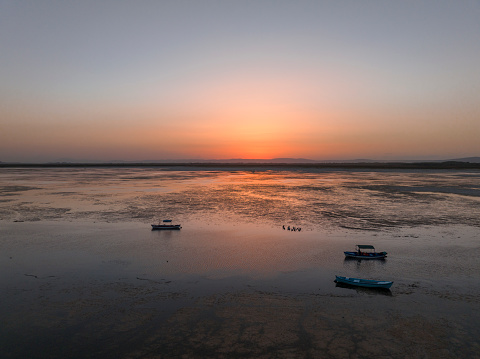 Fishing boats standing on the Acigol (Acıgöl) lake at a beautiful sunset. Denizli, Turkey. Taken via drone.