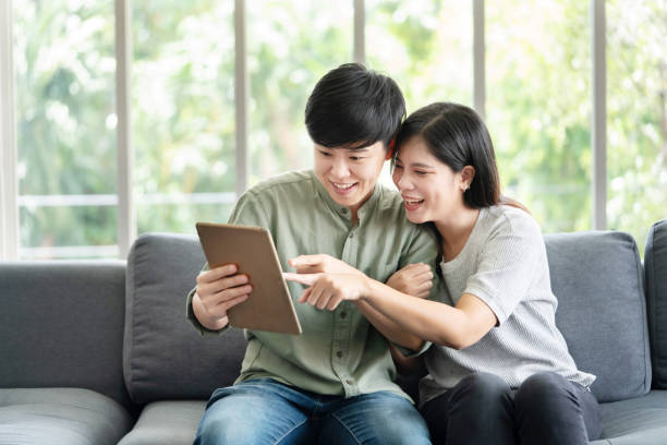 istock Asian LGBT Lesbian Couple Watching Tablet Screen on the Sofa 1429686413