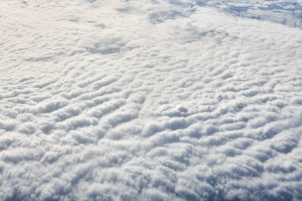 atemberaubender blick über wolken aus dem flugzeugfenster, dicke weiße blaue wolken sehen aus wie weicher schaum - cyclone stock-fotos und bilder