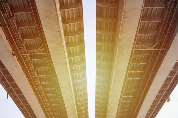 A railway viaduct stands tall, featuring multiple arches that support vital rail travel infrastructure under a bright blue sky with scattered clouds.