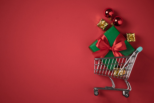 Shopping cart with Christmas presents top view. Christmas and New year shopping concept.