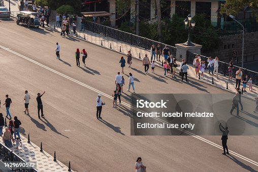 People walk on the Metekhi Bridge in Tbilisi.