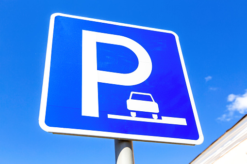Angle view on parking sign for cars against a blue sky background